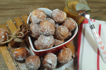Sweet small donuts in the platter in the shape of a heart. . The fat Thursday of carnival. Slavic tradition. Seasonal and festive concept
