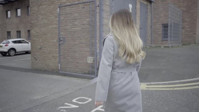 confident blonde woman walks to her car in office car park