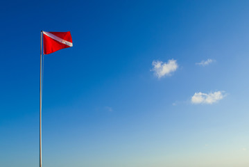 The divers down flag is the internationally recognized notification that there are divers in the water. This one has been shot against a clear blue sky in a topical location 
