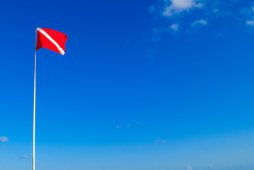 The divers down flag is the internationally recognized notification that there are divers in the water. This one has been shot against a clear blue sky in a topical location 