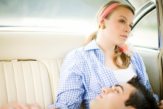 Young couple relaxing in the back seat of a car