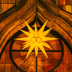 Herrnhuter Stern h&auml;ngt im Advent an einer Kirche
