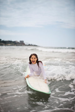 Young woman catching a small wave on her surfboard.