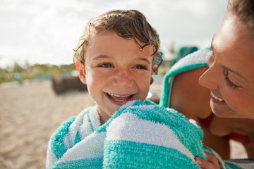 Laughing boy with his mother enjoying beach