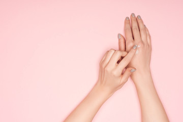 cropped view of woman applying hand cream isolated on pink