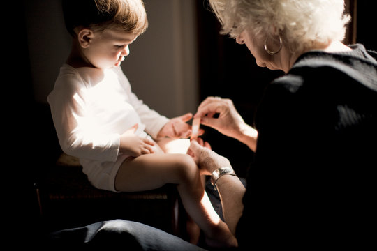 Grandmother putting a plaster on grandson.
