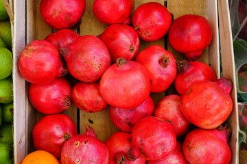 Fototapeta na wymiar Crate of fresh red pomegranate fruit