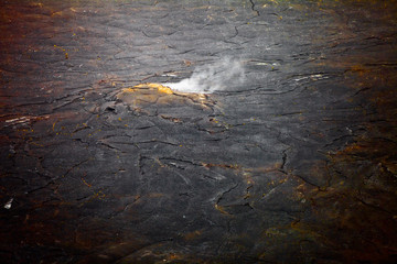 Steam rising up from a volcanic landscape.