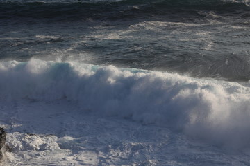 Strong wave of white sea beats on the rocks