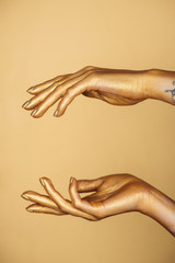 partial view of female painted hands isolated on gold