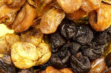 Delicious dried fruits dried apricots, prunes and figs as a background.