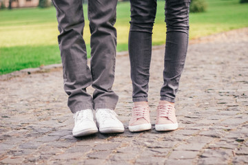 legs of a loving couple in sneakers