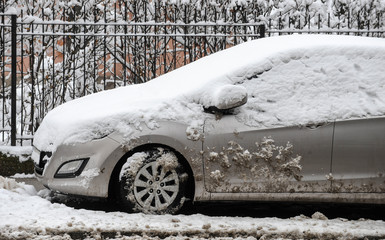 A car covered with snow parked on the street
