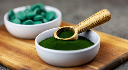 chlorella, spirulina green algae in powder and tablets form- closeup, macro shot