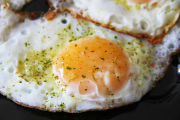 Roasted eggs on the black plate and spices