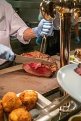Vertical photo of chef hand cutting BBQ Beef steak with knife and fork