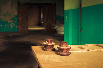 Electrical insulator on table inside abandoned old factory building. 