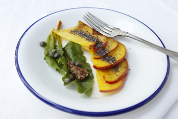 Sliced yellow beet carpaccio with mustard and capers.