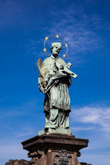 Fototapeta na wymiar St. John of Nepomuk 1683 antique sculpture on the medieval gothic Charles Bridge in Prague