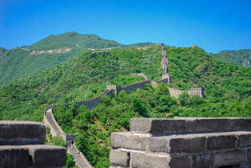 Fototapeta na wymiar The Great Wall of China seen through a stone parapet