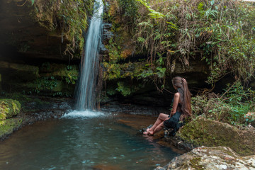 woman sitting next to waterfall