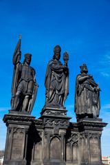 Fototapeta na wymiar Antique statue of Saints Norbert of Xanten, Wenceslas and Sigismund on the medieval gothic Charles Bridge in Prague built on the 15th century