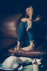 Obraz na płótnie Canvas Young drunk woman on the sofa. Young drunk woman on the sofa. Alcoholism and drug addiction lead to depression.