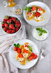 Belgian waffles with whipped cream and strawberries