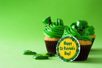 St. Patrick's Day cupcakes on green background. Copyspace