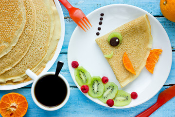 Funny pancakes with fruits shaped fish for kids breakfast © san_ta