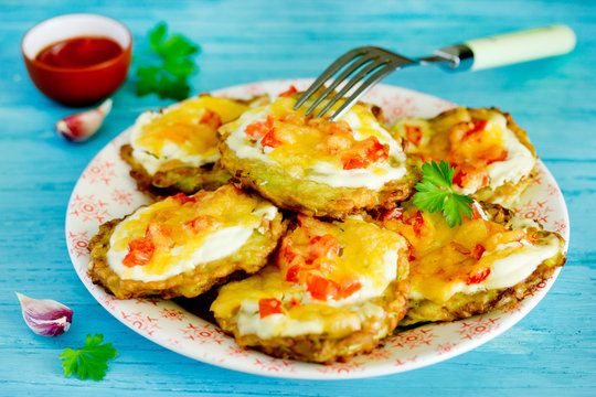 Zucchini fritters with sour cream, tomatoes and cheese