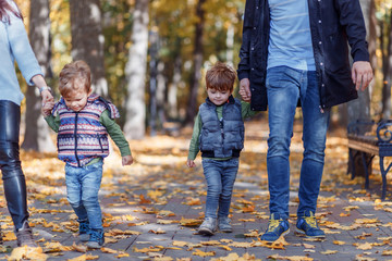 Natural pictures of a happy family of four having fun outsiade on a sunny autumn day. Togetherness and happiness concept