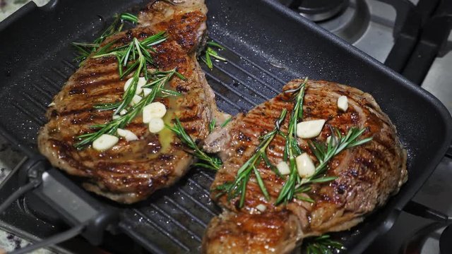 Cooking beef on grill frying pan on gas oven, closeup
