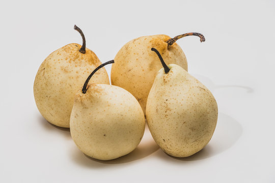 Four beautiful yellow Nesha pears on a white background