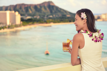 Hawaii vacation summer travel- Mai Tai and aloha spirit. Asian woman relaxing drinking Hawaiian...