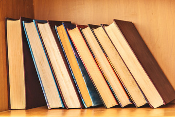 Big pile of books on wooden background.