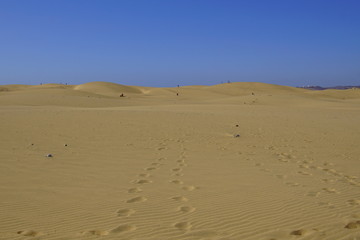 The Maspalomas Dunes (Spanish: Dunas de Maspalomas), against a clear blue sky