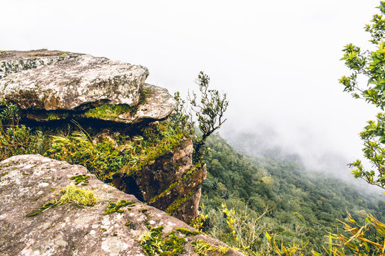 On top of Bokor Mountain above the clouds standing on a big loose rock
