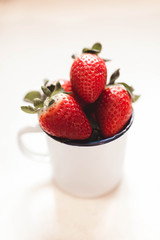 strawberries in a white enamel mug