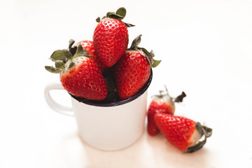 strawberries in a white enamel mug