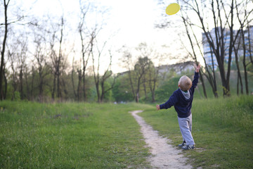 child boy playing park throws flying saucer