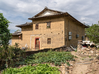 Fototapeta na wymiar Tea plantations around stone home by Tulou at Unesco heritage site near Xiamen