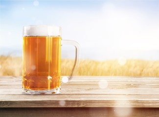 Mug of cold beer with foam, close-up view