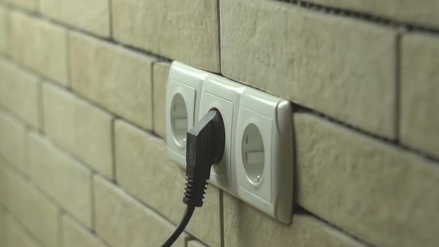 Man Push Electric Plug Into The Socket