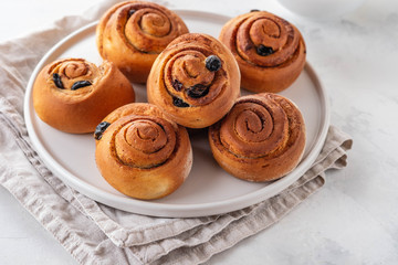 Freshly Baked Traditional Sweet Cinnamon Rolls, Swirl on white plate. Copy space.