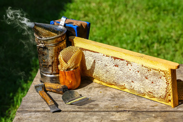 Beekeeper working tools on the hive. beekeeping equipment on a wooden table outdoors with copy space - obrazy, fototapety, plakaty