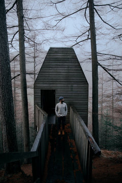 Man in front of a cabin in the woods