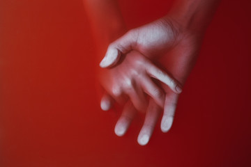 plexus of the hands of a man and a woman drowning in red water similar to blood, cover of a thriller or a detective story