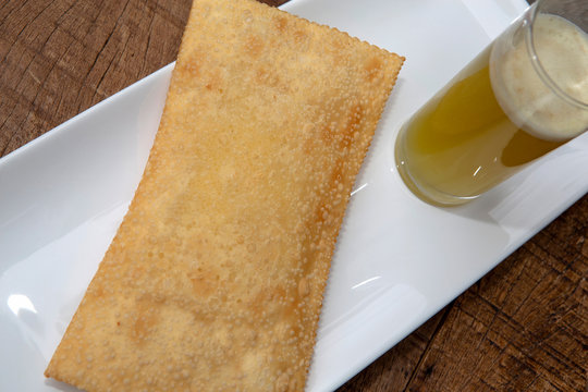 Pastel, or pastry in English, and glass of sugar cane juice