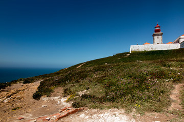Fototapeta na wymiar The westernmost lighthouse of Cabo da Roca in Porugalia with the yellow-flowered Hottentot fig growing
